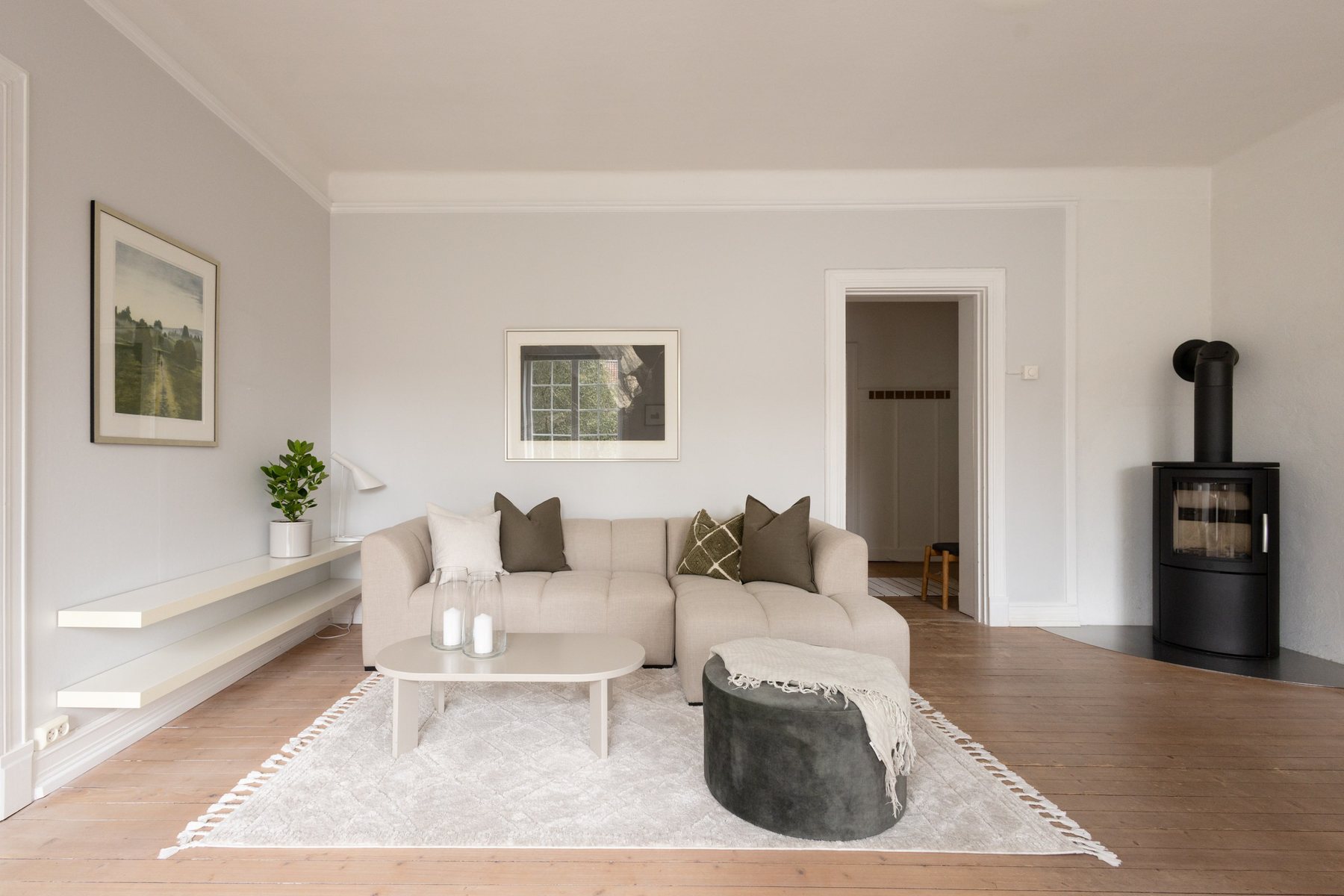 Stue med beige sofa og grønne detaljer